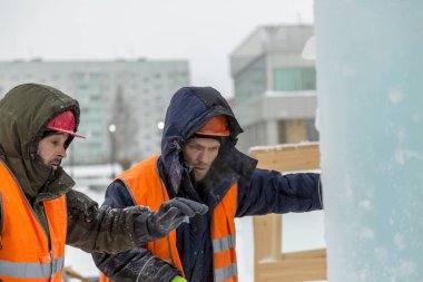 İşçiler Noel tatili için buz bloklarından bir buz kasabası inşa ediyorlar.