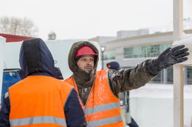 İşçiler Noel tatili için buz bloklarından bir buz kasabası inşa ediyorlar.