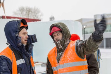 İşçiler Noel tatili için buz bloklarından bir buz kasabası inşa ediyorlar.