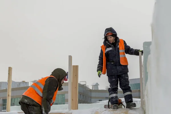 Workers build an ice town from ice blocks for the Christmas holidays