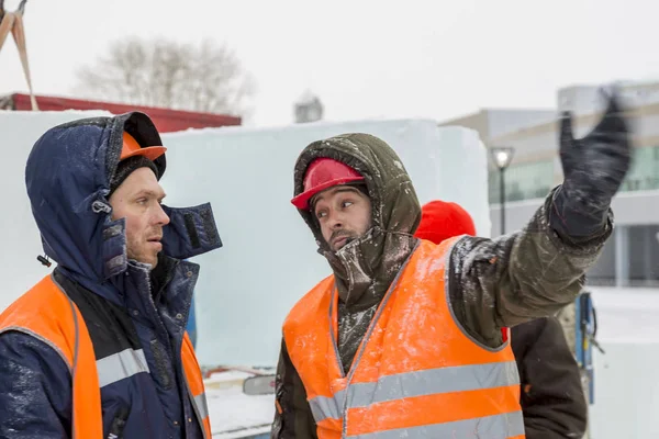 İşçiler Noel tatili için buz bloklarından bir buz kasabası inşa ediyorlar.