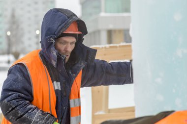 Çalışan bir koruyucu kask ve çalışma meast üzerinde yansıtıcı yelek tesisatçısı