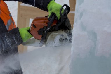 İşçi koruyucu bir kask içinde tesisatçısı ve yansıtıcı yelek bir buz levha testere ile kesme