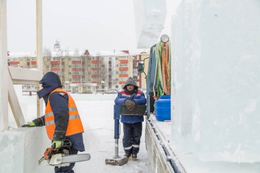İşçiler Noel tatili için buz bloklarından bir buz kasabası inşa ediyorlar.