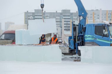 İşçiler Noel tatili için buz bloklarından bir buz kasabası inşa ediyorlar.