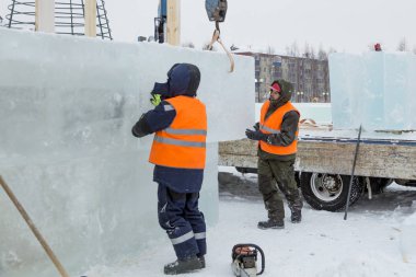 İşçiler Noel tatili için buz bloklarından bir buz kasabası inşa ediyorlar.