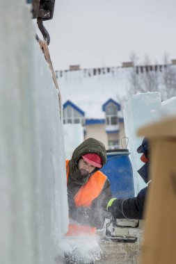 İşçiler Noel tatili için buz bloklarından bir buz kasabası inşa ediyorlar.