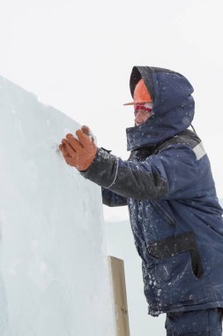 Buz kasabası kurmakla meşgul bir işçinin portresi.