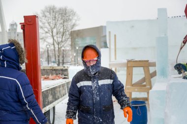 Buz kasabası kurmakla meşgul bir işçinin portresi.