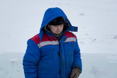 Buz kasabası kurmakla meşgul bir işçinin portresi.