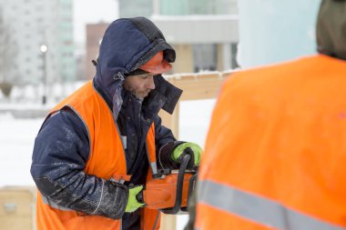 Testere ile bir koruyucu kask ve yansıtıcı yelek installer profilinde iş