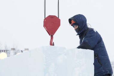 Buz levha boşaltma bir kukuleta ile bir ceket bir assembler işçi portresi