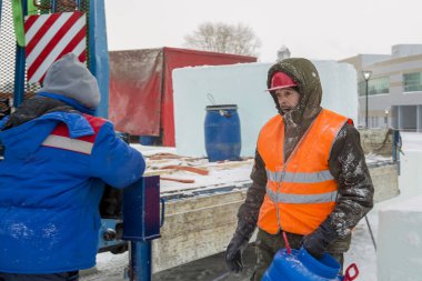 Mavi bir varil elinde tutan bir assembler işçi kapüşonlu ceket portresi