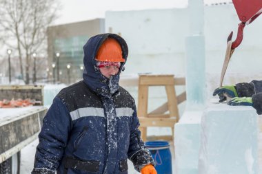 Buz kasabası kurmakla meşgul bir işçinin portresi.