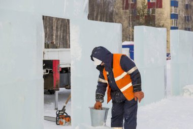 İşçiler Noel tatili için buz bloklarından bir buz kasabası inşa ediyorlar.