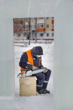 Elle çalışan biri elektrikli testere keskinleştirir.