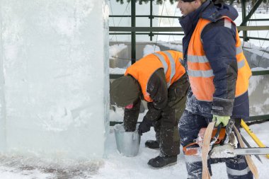 İşçiler Noel tatili için buz bloklarından bir buz kasabası inşa ediyorlar.