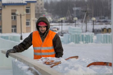 Bir ceket ve kask tesisatçısı askı kurulları kaldırır