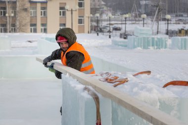 Bir ceket ve kask tesisatçısı askı kurulları kaldırır