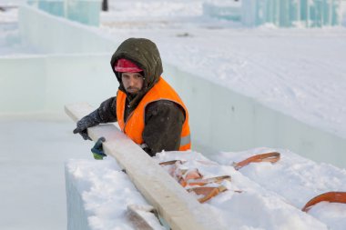 Bir ceket ve kask tesisatçısı askı kurulları kaldırır