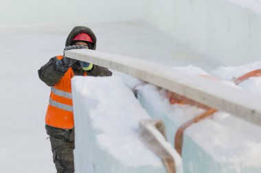 Bir ceket ve kask tesisatçısı askı kurulları kaldırır