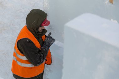 Buz levha boşaltma bir kukuleta ile bir ceket bir assembler işçi portresi