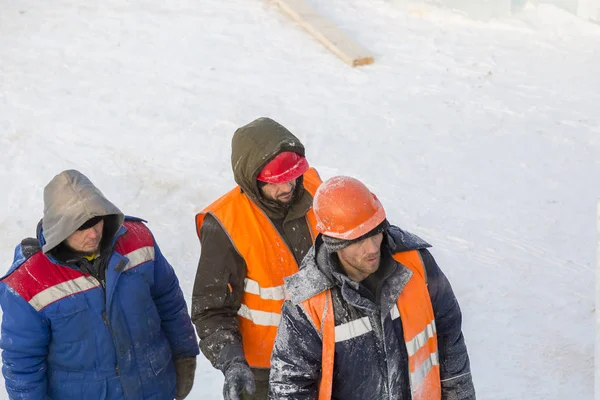 Workers on the construction of an ice camp discuss a plan