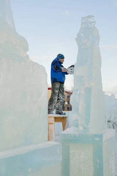 Der Bildhauer Schneidet Die Eisfigur Des Weihnachtsmannes Aus Einem Kettensägeneis — Stockfoto