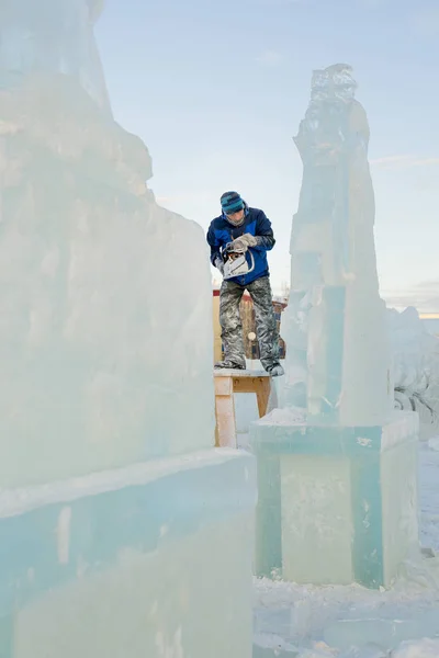 The sculptor cuts the ice figure of Santa Claus for Christmas from a chainsaw ice