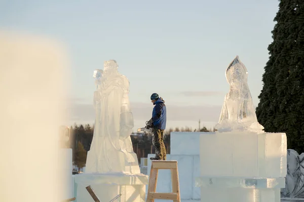 Der Bildhauer Schneidet Die Eisfigur Des Weihnachtsmannes Aus Einem Kettensägeneis — Stockfoto