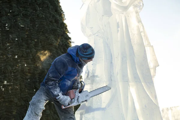 Der Bildhauer Schneidet Die Eisfigur Des Weihnachtsmannes Aus Einem Kettensägeneis — Stockfoto