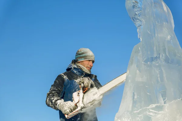 Der Bildhauer Schneidet Die Eisfigur Des Weihnachtsmannes Aus Einem Kettensägeneis — Stockfoto