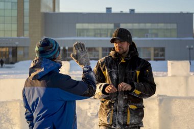 Bir konuşma için buz şehrin inşaat sahasında işçiler