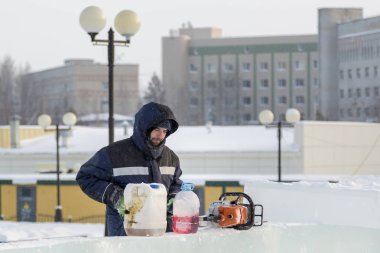 İşçi el ile Gönderen benzinli testere doldurur