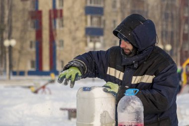 İşçi el ile Gönderen benzinli testere doldurur