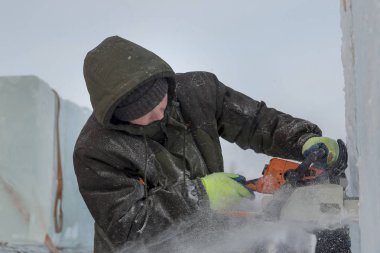Çalışan bir chainsaw buz plaka bir buz şehirde testereleri