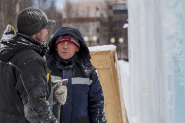 Bir konuşma için buz şehrin inşaat sahasında işçiler