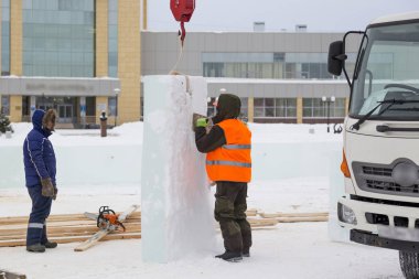 İşçi buz panelinden metal bir fırçayla karı kaldırıyor