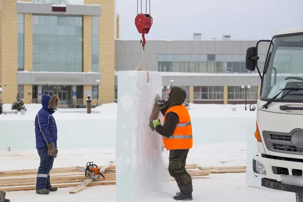 İşçi buz panelinden metal bir fırçayla karı kaldırıyor