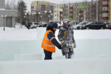 Bir konuşma için buz şehrin inşaat sahasında işçiler