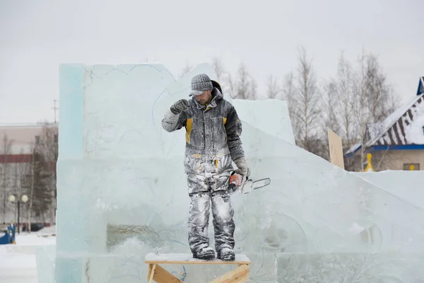 Portrait of an assembler worker in a jacket with a hood at the construction of an ice camp