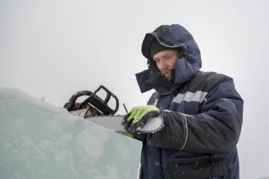 Elle çalışan biri elektrikli testere keskinleştirir.