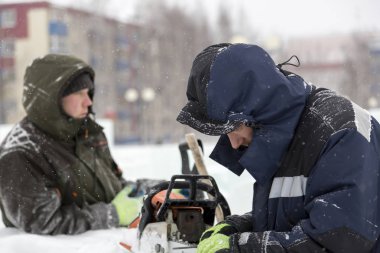 Elle çalışan biri elektrikli testere keskinleştirir.