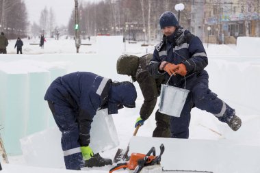 İşçiler Noel tatili için buz bloklarından bir buz kasabası inşa ediyorlar.