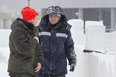 Bir konuşma için buz şehrin inşaat sahasında işçiler