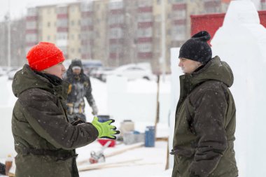 Bir konuşma için buz şehrin inşaat sahasında işçiler