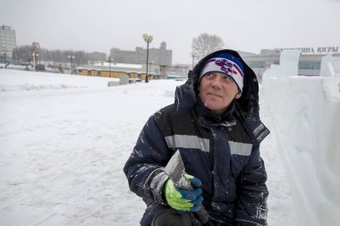 Buz kasabası kurmakla meşgul bir işçinin portresi.