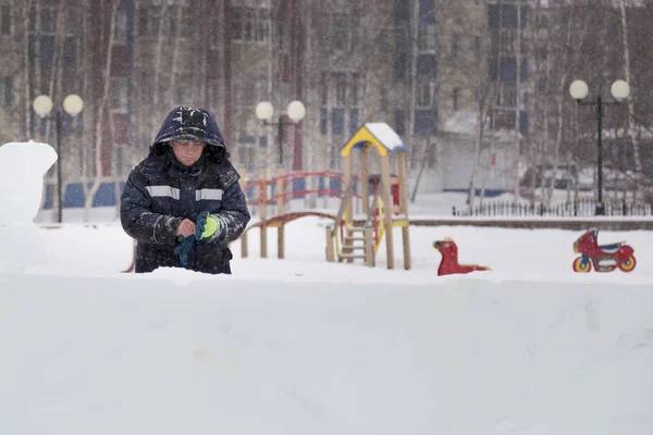 Buz kasabası kurmakla meşgul bir işçinin portresi.