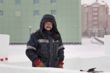 Buz kasabası kurmakla meşgul bir işçinin portresi.