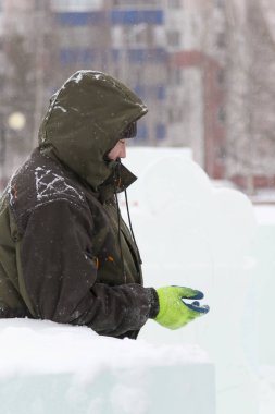 Buz kasabası kurmakla meşgul bir işçinin portresi.